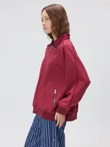 Buzo de algodón con cuello alto y cierre frontal parcial. Presenta bolsillos laterales con cierre y cuello con interior en contraste. Diseño de corte oversize.