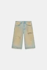 Bermuda de denim de tiro medio y corte baggy, con diseño de cinco bolsillos, trabillas para cinto y rotos decorativos.