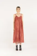 Vestido midi lencero de viscosa y seda, color salmón, con breteles regulables, escote en V, silueta evasé con vuelo, bolsillos laterales y ruedo deshilachado.