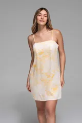 Vestido corto de tirantes finos, con estampado zodiacal en tonos amarillo, marrón y azul sobre fondo blanco.