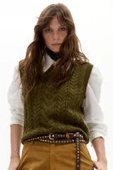 Chaleco de punto color verde militar, con cuello a la base, diseño de ochos en el frente y terminaciones de rib.