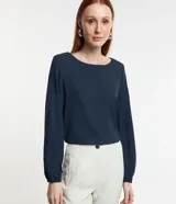 Blusa azul marino de crepé con escote redondo y mangas largas con puños elásticos.