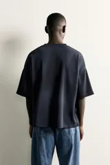 Camiseta de corte relajado con cuello redondo y manga corta. Presenta un diseño con bordados y estampados combinados a contraste en el frente con la inscripción 'New York City' y un efecto de lavado en la tela.
