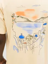 Remera color crema de algodón con cuello redondo, manga corta y estampado en la espalda con un paisaje costero.