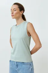 Musculosa de algodón color verde menta, con cuello redondo y detalle de botones decorativos en los hombros.