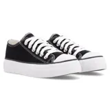 Zapatillas bajas de lona negra con suela de plataforma blanca, cordones blancos y etiqueta con logo en la lengüeta.