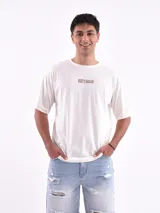 Remera blanca de corte holgado con la frase "The Good Old Days" estampada en color naranja.