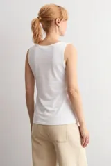 Musculosa blanca básica de corte recto, con escote redondo a la base y tirantes anchos.