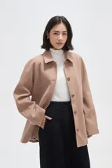 Tapado de paño color gris, con cuello camisero, cierre frontal de botones y bolsillos laterales con solapa.