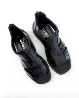 Sandalias negras de cuero con textura escamada, corte asimétrico y suela track.