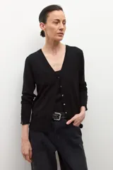 Cardigan negro de tejido fino, con escote en V y cierre frontal de botones plateados. Presenta aberturas en los puños.