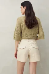 Short color verde militar, de tiro medio, con bolsillos delanteros y traseros.