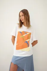 Remerón oversize de algodón blanco con estampado frontal de dos mujeres en bikini, con texto "Muertas de calor, cu pa arriba. Amiga hacerme un lugar. Desátame la bikini. Me quedo la marca? Pásame el Hawaiian. Eterno enero."