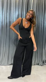 Body negro de escote profundo en V, sin mangas, con corte cavado en la parte inferior y confeccionado en tejido elástico.