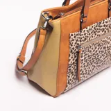 Bolso tipo tote bag de mujer, con cuerpo principal en color camel y paneles laterales en verde oliva con textura de cocodrilo. Presenta un bolsillo frontal con estampado de leopardo. Las asas de mano y la correa ajustable son de color camel con costuras visibles.