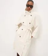 Trench coat Cortelle de gabardina de viscosa color beige, con diseño largo, mangas largas, cuello alto con solapas y cierre cruzado con botones carey. Incluye tira para anudar en la cintura y bolsillos laterales.