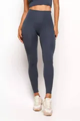 Calza deportiva de tiro alto en color gris oscuro, confeccionada en poliamida de alta elasticidad. Presenta un diseño minimalista con costuras verticales estratégicas en el frente y la espalda para un efecto modelador y estilizado.