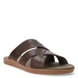 Sandalias de cuero marrón con diseño de tiras cruzadas, una de ellas con textura perforada. Poseen suela plana de goma en tono caramelo.
