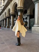 Poncho de hilo liviano en color crema, con diseño de cuello redondo y caída fluida, ideal para media estación.