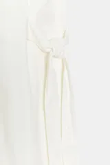 Vestido midi camisero de algodón color negro, con cuello solapa, sin mangas y cierre frontal con botones ocultos por solapa. Incluye cintura ajustable con tiras de lazada lateral en el mismo tejido.