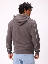 Canguro gris con capucha, cierre frontal completo y bolsillos tipo canguro. Presenta detalles de líneas blancas en las mangas y estampados gráficos en el pecho.