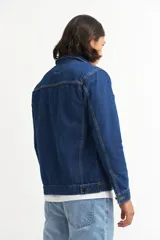 Campera de jean celeste con cuello clásico, cierre frontal con botones metálicos negros, bolsillos con solapa abotonada en el pecho y mangas largas con puños abotonados.