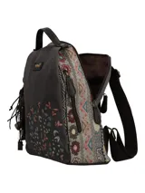 Mochila de tela color gris oscuro con bordado floral en la parte inferior derecha del frente. Los laterales y la parte superior presentan un diseño patchwork multicolor. Incluye un llavero colgante con flecos y dijes. Tiene un asa superior, cierre de cremallera en el compartimento principal, bolsillos laterales, bolsillo trasero y bolsillo interior, todos con cierre. Las correas de hombro son ajustables.