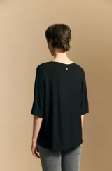 Remera de calce relajado con silueta fluida, confeccionada en tejido de viscosa con elastano. Presenta cuello redondo, mangas cortas y un diseño minimalista de caída suave.