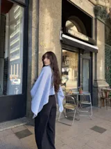 Poncho de hilo liviano en color celeste, con cuello alto y diseño de caída fluida y holgada.