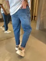 Jean de corte slouchy con lavado azul medio, diseño de tiro medio y ajuste holgado en las piernas con terminación ligeramente estrecha en los tobillos.