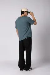 Pantalón de jogging de corte recto y fit relajado, confeccionado en tejido de algodón de color gris azulado. Presenta una caída amplia, cintura elástica y un pequeño logo bordado en la parte superior del muslo.