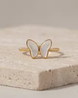 Anillo de acero con baño de oro y diseño de mariposa con nácar.