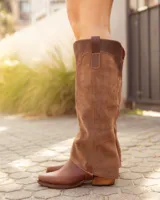 Bota alta de cuero y gamuza color marrón, con diseño 2 en 1 que incluye estribo desmontable, taco cuadrado y punta cuadrada.