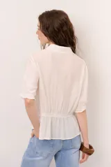 Camisa beige de manga corta con cuello camisero, detalles de encaje y cierre frontal con botones.