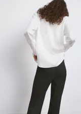Camisa oversize blanca de lyocell, con mangas largas y cierre frontal de botones.