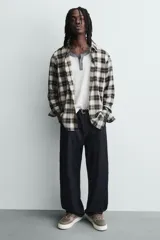 Zapatillas marrones de estilo retro con cordones, capellada de cuero y suela de goma color crema.