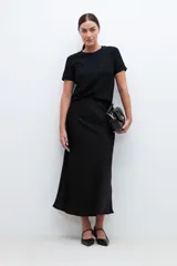 Blusa negra de broderie con mangas cortas y cuello redondo.