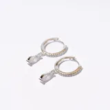 Aros plateados con forma de argolla con incrustaciones de circonitas y dije colgante de circonita blanca en forma de lágrima.