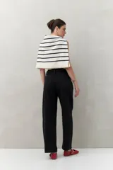 Pantalón de jean azul oscuro, de tiro alto y corte amplio con pinzas centrales.