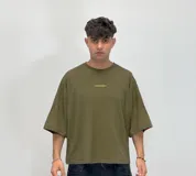 Remera de corte boxy fit color beige, con estampa gráfica en la espalda en color marrón que incluye el logo de la marca y texto descriptivo.