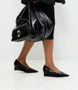 Zapato estilo scarpin con taco anabela de 5 cm, confeccionado en poliuretano con acabado liso y punta fina. Diseño minimalista y cerrado, ideal para uso diario o formal.