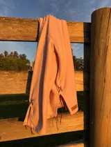 Sweater de tejido de punto suave en color rosado, con diseño holgado, cuello redondo y aberturas laterales en el ruedo.