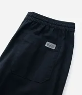 Pantalón de sarga corte relaxed, color negro, con cintura elástica y lazo de ajuste. Cuenta con bolsillos laterales y diseño liso.