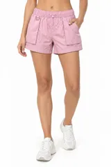 Short holgado de poliamida color rosado, con tiro bajo, cintura elástica con cordón ajustable, bolsillos cargo laterales y detalle de argolla metálica.