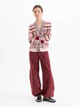 Cardigan de tejido de punto con diseño de cuadros en tonos rosados, rojos y blancos. Presenta cuello en V, cierre frontal con botones forrados y detalles de hilado metálico en la cartera. De corte recto y mangas largas.