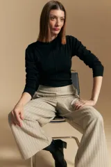 Polera de manga larga color marrón claro, con cuello alto y costura vertical decorativa en el frente.