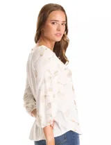 Blusa de tejido fino color marrón con bordado floral en hilo dorado. Presenta cuello redondo, mangas tres cuartos abullonadas con puños elásticos fruncidos y ruedo redondeado con corte asimétrico.