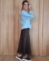 Pollera larga de denim en color gris, con corte acampanado, costuras verticales decorativas y cierre posterior.