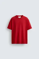 Camiseta de corte relajado confeccionada en tejido de algodón compacto. Presenta cuello redondo con acabado de rib doble y mangas cortas. Su apariencia única es resultado de un proceso especial de tintado y acabado.