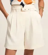 Bermuda de sastrería color crudo, de corte recto y cintura alta, con trabillas, cinturón y cierre por cremallera.